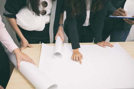Asian women and men engineers discussing business project and smiling in office,soft focus and blurryの写真素材