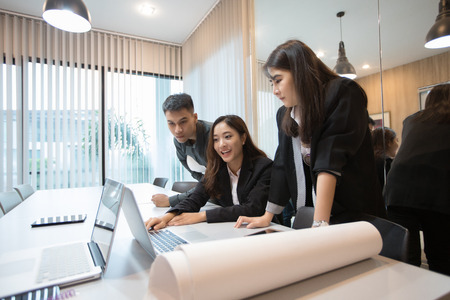 Asian businessmen and group using notebook for meeting and business women smiling happy for working