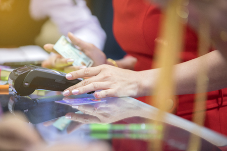 Asian Business women hand using credit card swiping machine for payment in cafeteria and supermarketの写真素材