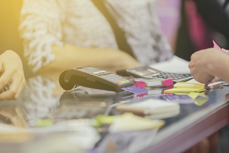 Asian Business women hand using credit card swiping machine for payment in cafeteria and supermarket