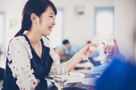 Asian young couple enjoying a romantic dinner  evening drinks while sitting at the dinning table on the kitchen together,soft focusの写真素材