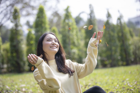 Beautiful Asian woman Smiling happy girl and wearing warm clothes winter and autumn portrait at outdoor in parkの写真素材