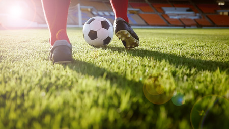 soccer or football player standing with ball on the field for Kick the soccer ball at football stadiumの写真素材