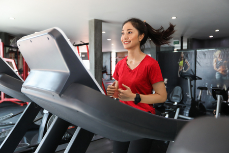 Asian women running sport shoes at the gym while a young caucasian woman is having jogging on the...
