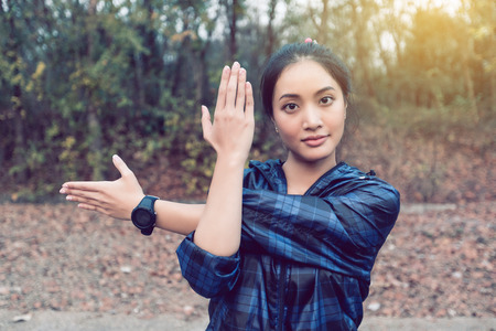 Athletic woman asia warming up and Young female athlete exercising and stretching in a park before Runner outdoors, healthy lifestyle concept.の写真素材