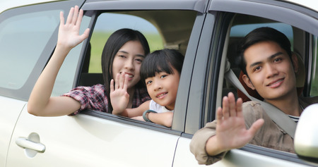 Happy little girl  with asian family sitting in the car for enjoying road trip and summer vacation in camper vanの写真素材