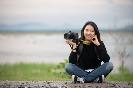 sian  young women people Hiking with friends backpacks walking together and looking map and taking photo camera by the road and looking happy ,Relax time on holiday concept travelの写真素材