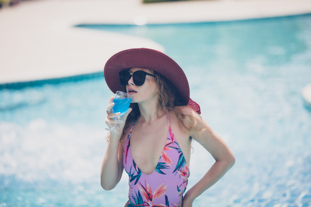 Women wear bikinis and drinking cocktails in the hot summer at the swimming pool.の写真素材