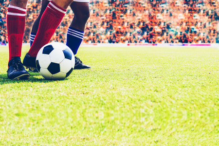 football player kicking ball on the fieldの写真素材