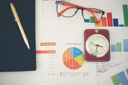 Business concept of office working and analysis graphics and clock on tableの写真素材