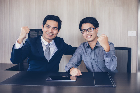 Asian businessmen Success and winning concept - happy team with raised up hands celebrating the...