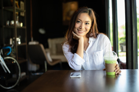 Asian women  smiling and happy Relaxing in a coffee shop after working in a successful office.の写真素材