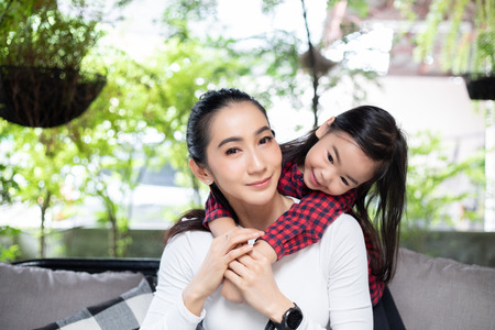 The daughter is hugging her mother and laughing happyの写真素材