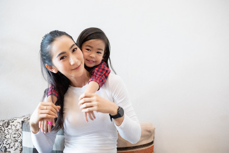 The daughter is hugging her mother and laughing happyの写真素材