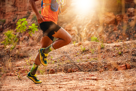 A man Runner of Trail . and athlete's feet wearing sports shoes for trail running in the mountains , soft focus and blurryの写真素材