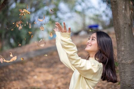 Beautiful Asian woman Smiling happy girl and wearing warm clothes winter and autumn portrait at outdoor in parkの写真素材