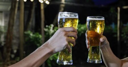 Asian group of friends having party with alcoholic beer drinks and Young people enjoying at a bar toasting cocktails and clinking glassesの写真素材