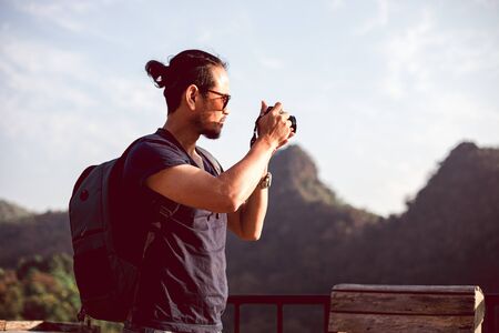 Asian men backpacks and traveler walking together and happy are taking photo on mountain, Relax time...