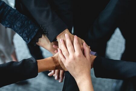 Happy Business people showing team work and giving five after signing agreement or contract with...