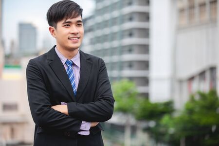Happy handsome businessman standing and smiling  at outdoorの写真素材