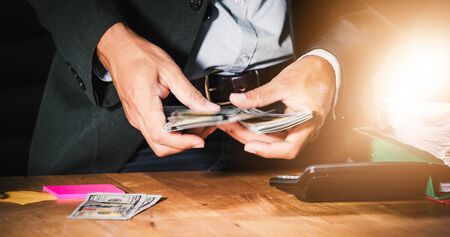 Businessmen count money and plan finances for projects and use calculators for analysis project documents and graph financial diagram working in the background on office tableの写真素材