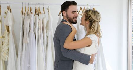 The lovers give flowers to the bride and kissed happy and couple love standing in wedding studio