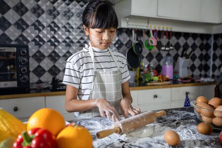Happy Family and their little daughter preparing a pizza, knead the dough and puts ingredients on...