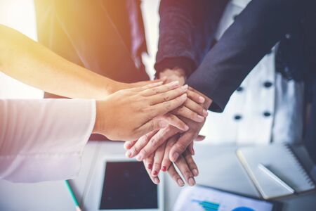 Happy Business people showing team work and giving five after signing agreement or contract with...