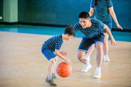 Asian family playing basketball together. Happy family spending free time together on holidayの写真素材