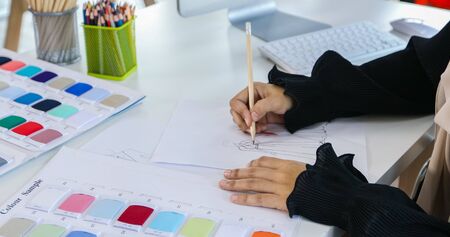 Small business of Muslim woman fashion designer Working and  using smart phone and tablet With Dresses at clothing storeの写真素材