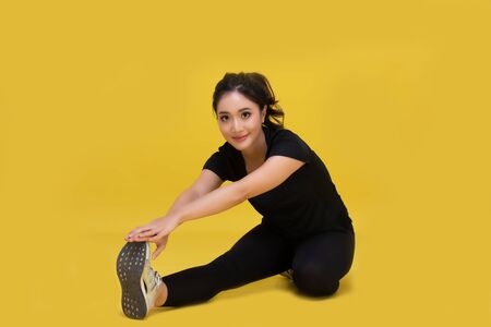 Smile happy Beautiful portrait young Asian woman stretching exercise workout on yellow background,...