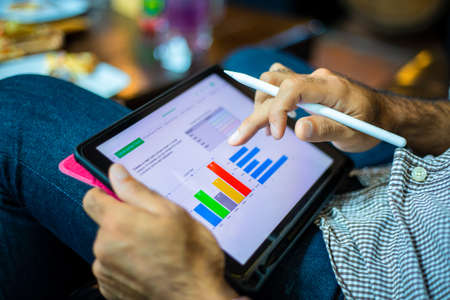 Asian business men using a tablet for working at coffee shopの写真素材