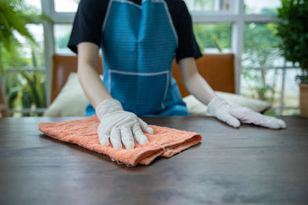 Asian women wearing glove and Cleaning table at homeの写真素材