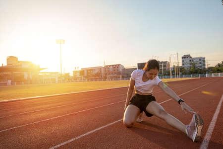 smiling women asian runner doing stretching exercise, preparing for morning workout and lifestyle...