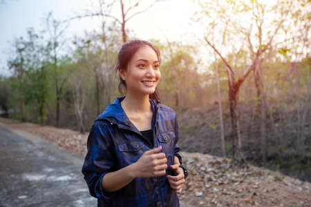 smiling happy Asian woman is jogging and running on relax time and she wears a fitness watch or sport watch.の写真素材