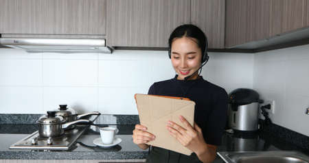 Asian women wearing headphone and using digital tablet video Conference and meeting and drinking...