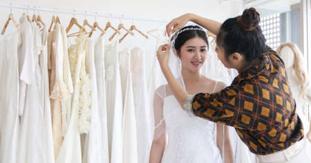 Small Business of Asian women Fashion Designer Working With Wedding Dresses at  clothing store