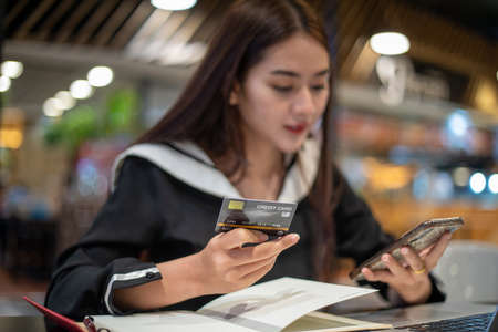 Beautiful Asian women holding credit card and mobile phone for shopping online.she smiling and happyの写真素材