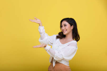 Portrait Asian beautiful happy young woman smiling cheerful  isolated on yellow studio backgroundの写真素材