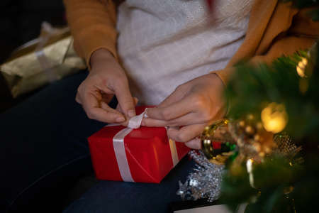 Asian Happy family with daughter in Santa hats gathered together on Christmas time and enjoy gifts...