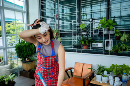 Asian Young Beautiful Woman is Dancing and Cleaning with Mop a Bright Cozy Room at Home. She's Happy...