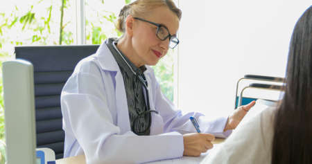 Women Doctor talk with woman patient in his office at Hospitals,Healthcare concept