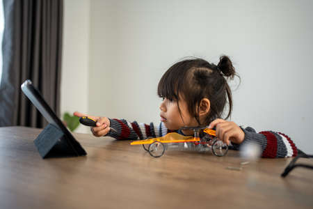 Asian girls enjoy making and fixing electrical robot car and learning online tutor training course