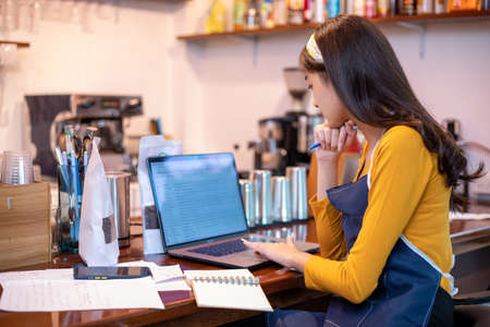 Asian women Barista smiling and using coffee machine in coffee shop counter - Working woman small business owner food and drink cafe conceptの写真素材