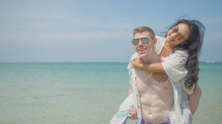 A couple hugs and kisses on the beach on their summer vacation and they smile and are happy on vacation.の写真素材