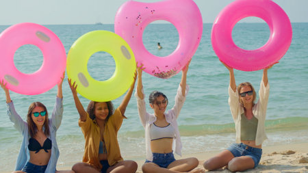 A group of teenage girls run and play at the beach for their summer vacation and they smile and enjoy their vacation.の写真素材