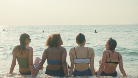 A group of teenage girls run and play at the beach for their summer vacation and they smile and enjoy their vacation.の写真素材