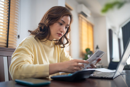 Asian woman calculating and stressing about household bills