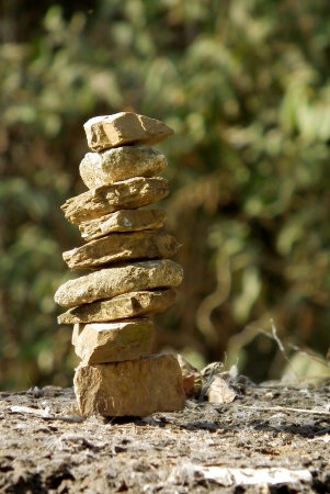 A stack of three zen rocks are in the forest with trees in the background to add a text messageの写真素材