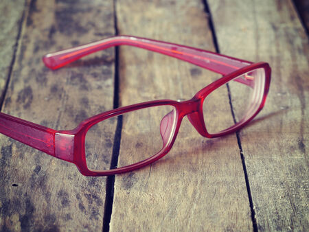 red glasses on wood background retro-vintage styleの写真素材